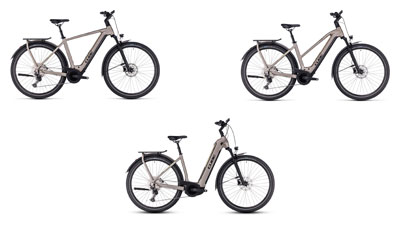 Sono esposte tre e-bike Cube Kathmandu Hybrid grigie, ciascuna con telaio a diamante, telaio trapezoidale e telaio a scavalco basso.