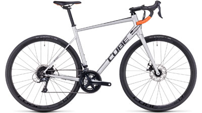 Bicicletta da corsa Cube Attain Pro in argento con manubrio drop bar arancione.