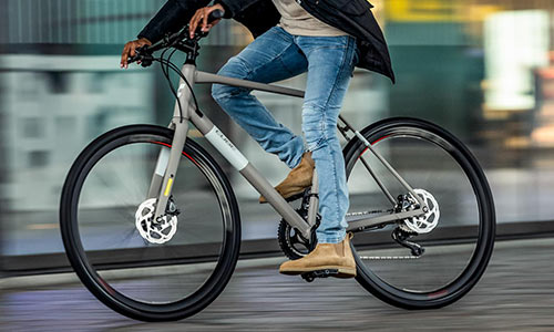 Un ciclista attraversa la città con la sua bicicletta da fitness, il ciclista è visibile solo in parte.