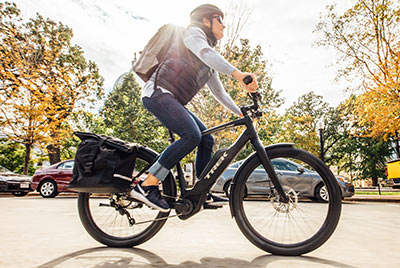 Un uomo sta percorrendo una strada in sella a una bicicletta nera di marca Trek.