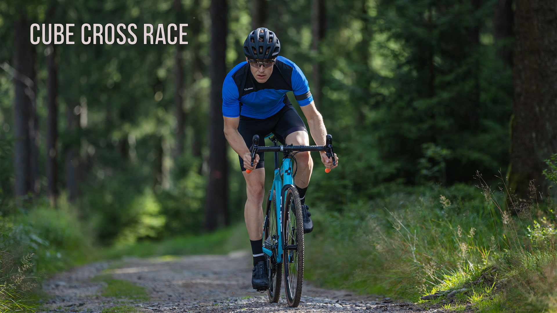 Un uomo attraversa il bosco con una bicicletta Cube Cross Race.